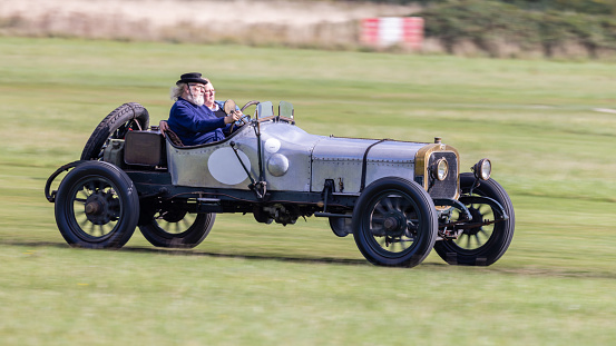 old Warden, UK - 2nd October 2022: Vintage car 1911 Sunbeam 12/16 being driven at speed along a grass runway