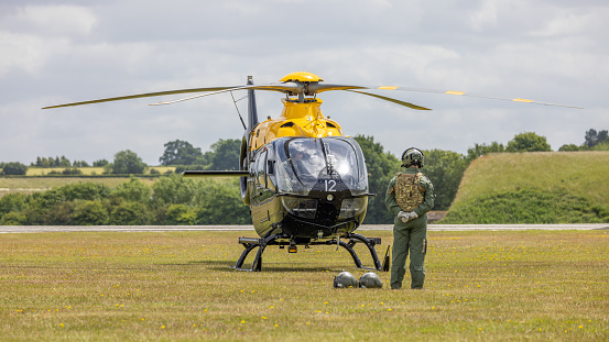 Cosford, UK - 12th June 2022:  A Eurocopter EC 135T1 sitting on the airfield with aircrew standing nearby