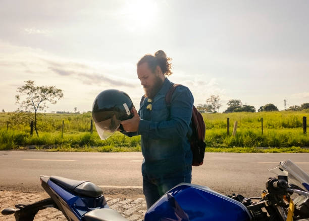 Photo of a man and his motorcycle in a rural place.Freedown.
