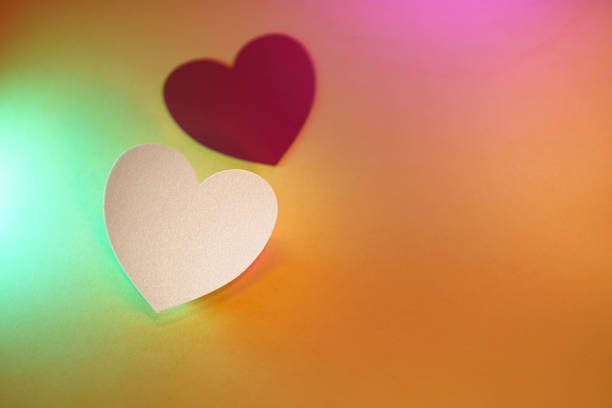 Heart-shaped paper cutouts. Valentine's Day template. Pastel colors. Colorful background.