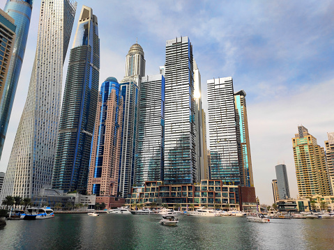Dubai, UAE - January 25, 2024: Skyscrapers in Marina Bay district seen from Marina promenade. Urban development. Famous Cayan and Princess Towers. Travel destination