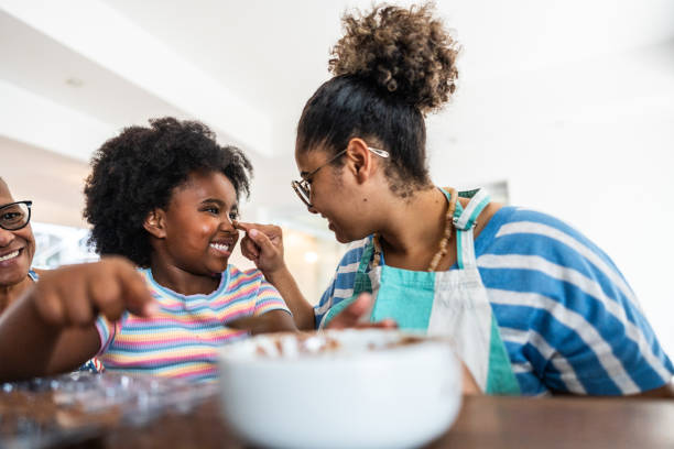 istock Mother pouring chocolate on daughters nose at home 1982794011