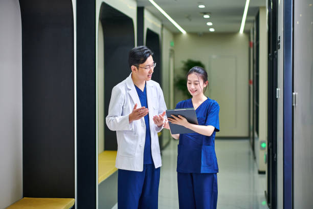 istock Doctor and Nurse Discussing at Clinic Corridor 1982796603
