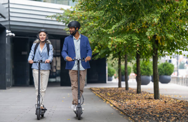 Smiling couple riding electric scooter stock photo