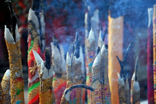 Amidst the ancient echoes of Baolun Temple in Chongqing, a tableau of devotion unfolds. Vibrant donated incense, wrapped in hues of deep purple, yellow, green, and orange, gracefully releases ethereal smoke at the Buddhist altar, weaving a spiritual symphony in the air.