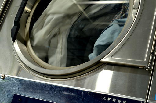 Close up on clothes dryer spinning, in use