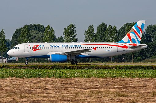 Hoofddorp, Netherlands - August 4, 2009: Turkish IZair Airbus A320-200 with registration TC-IZL rolling on taxiway V of Amsterdam Airport Schiphol