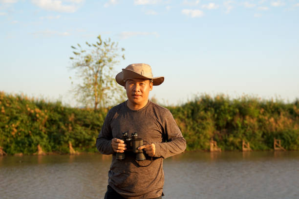 Mature man takes photo by water's edge, Nha Trang