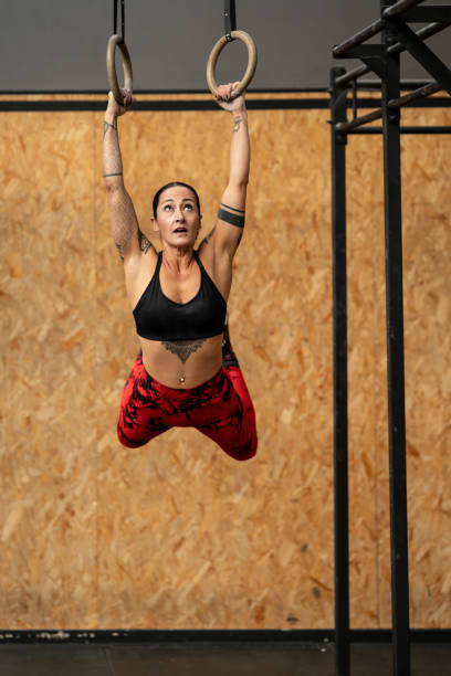 istock Sportive woman hanging from olympic rings while working out 1983024985