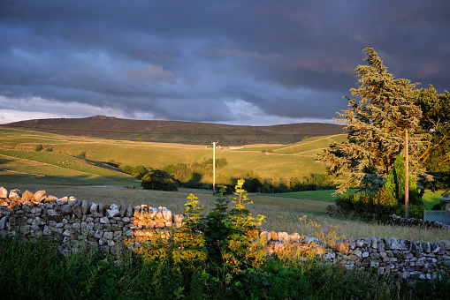 A sunset view showing a drystone wall looking towards, Ewe Close Scar in Hartlington , in the Yorkshire Dales, North Yorkshire.