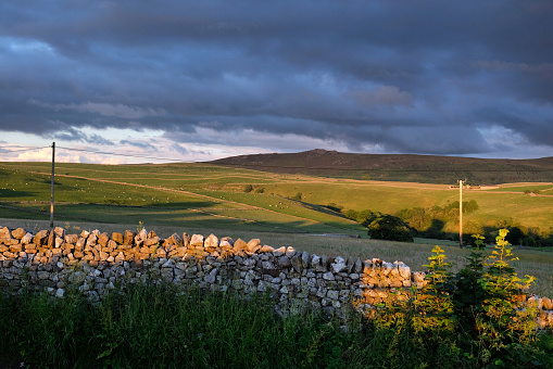 A sunset view showing a drystone wall looking towards, Ewe Close Scar in Hartlington , in the Yorkshire Dales, North Yorkshire.