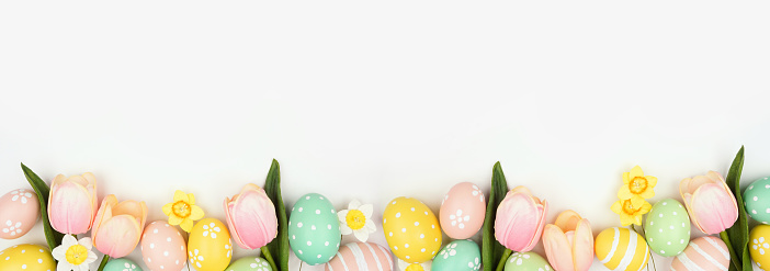 Easter eggs decorated with decoupage technique on a white board on a light blue background with copy space