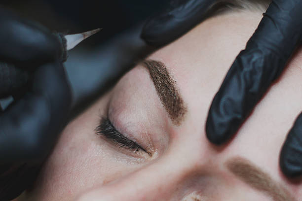 istock master in black gloves makes permanent eyebrow makeup close-up 1983055675