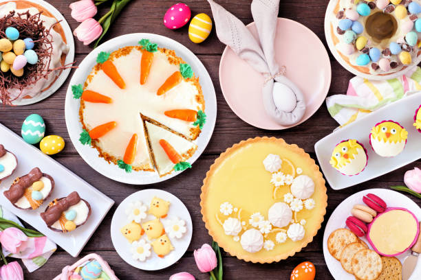 istock Easter or spring dessert food table scene. Top down view over a dark wood background. 1983056188
