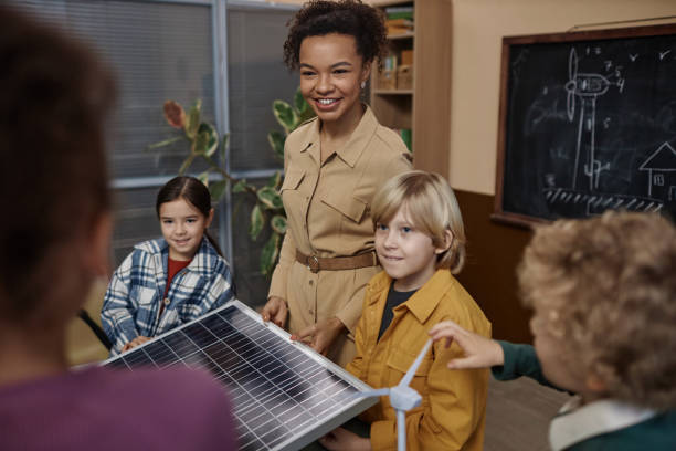istock Smiling Teacher Showing Solar Panel to Class of Kids 1983165485