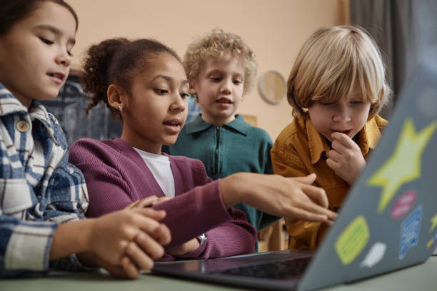 istock Diverse Group of School Children Looking at Computer Screen Together 1983166032