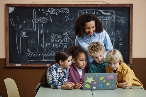 istock Diverse Group of Kids Using Computer with Smiling Female Teacher 1983166034
