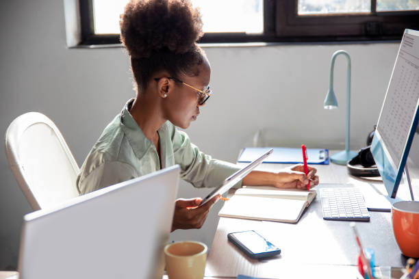 istock Black Woman working at office desk 1983242371