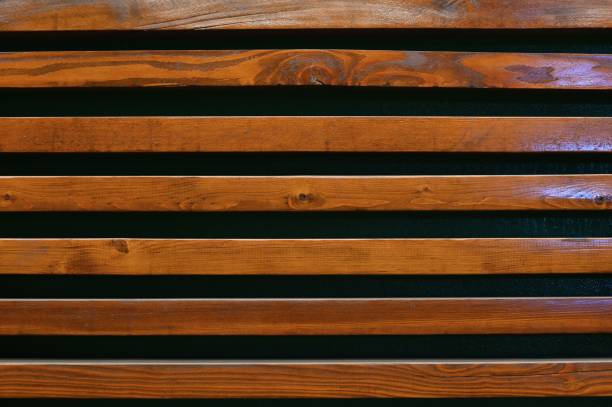 istock Horizontal lacquered wooden decorative planks illuminated by electric light on a dark background 1983273735