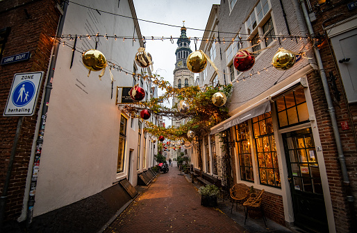 Historic street with Christmas decorations and a cathedral belltower in the background - Middelburg, the Netherlands