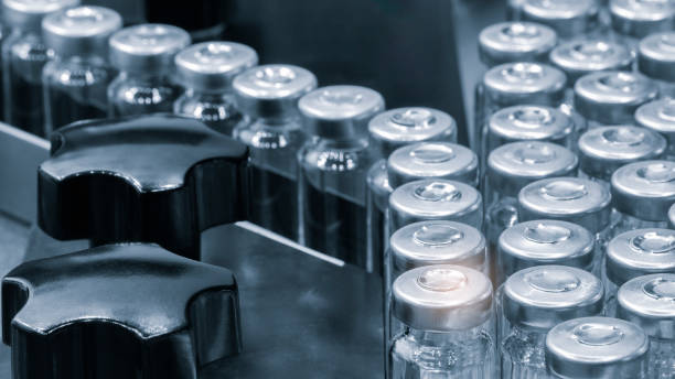 istock Pharmaceutical industry. Production line machine conveyor with glass bottles ampoules at factory. Pharmaceutical industry concept background. 1983285683