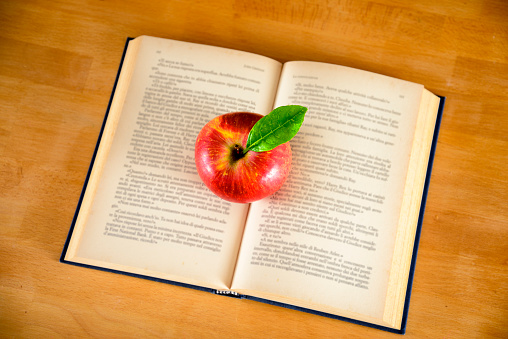 Red apple on old book.