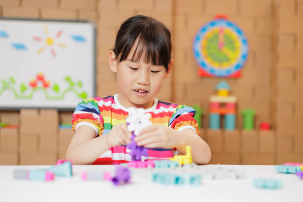 medium shot young girl playing Construction toys at home