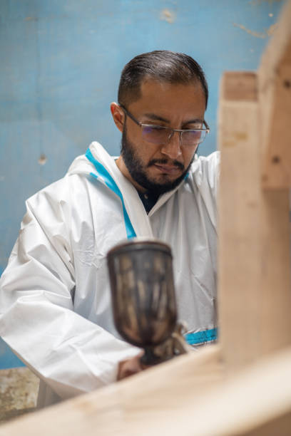 istock man using lacquer gun for painting, craft work tools on furniture, industrial 1983303664
