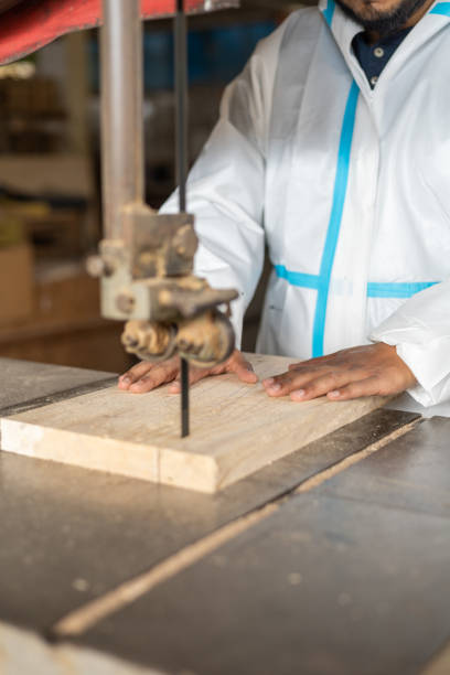 working with wood, hands of a person making a cut with a saw, occupation of carpentry and industrial tools