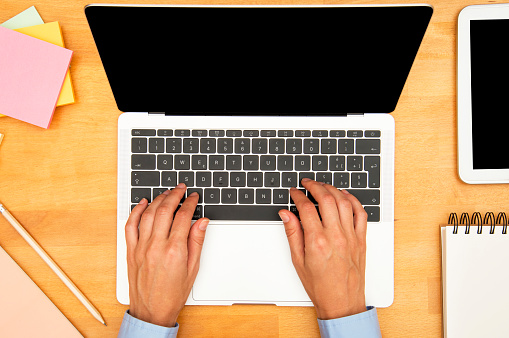 Businesswoman using laptop at desk.