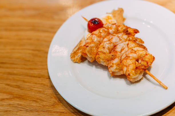 Fragment of shrimp salad with mushrooms. Close-up. It is located on a white surface.