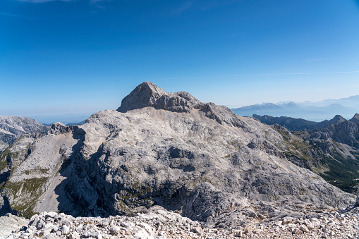 Close up of north side of Mt. Triglav on sunny day. Photo taken from the top of Mt. Kanjavec, 2569 m. People on the top.