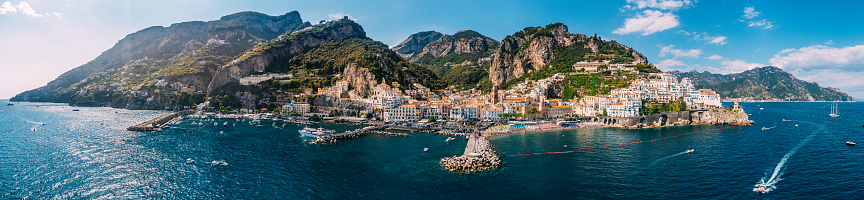 As seen from afar, the Amalfi Coast is a picturesque stretch of coastline in southern Italy, known for its dramatic cliffs, vibrant seaside villages, and stunning views of the Tyrrhenian Sea.
