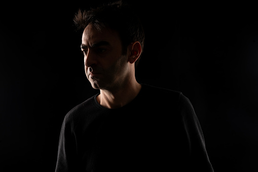 backlit portrait of man. Photographed in a dark environment. It was shot in a studio environment with a full frame camera.