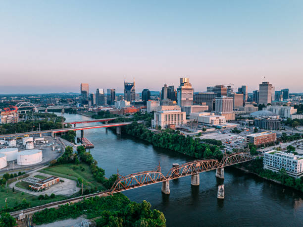 Aerial View of Railroad Bridge and James Robertson Parkway Bridge Downtown Nashville, Tennessee on a Sunny Autumn Evening from Across the Cumberland River Aerial Point of View of Music City, Downtown Nashville, Tennessee from the North Side of the Cumberland River near Nissan Stadium. nashville tennessee bridge stock pictures, royalty-free photos & images