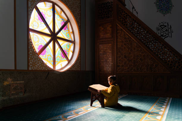 istock Boy sitting in mosque reading Quran 1983352117