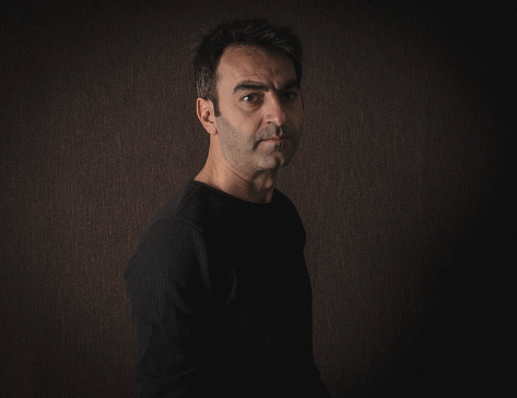 Portrait of man photographed in retro style. Photographed in a dark environment. It was shot in a studio environment with a full frame camera.