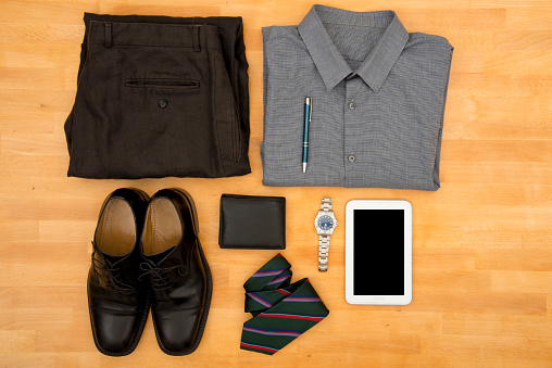 Businesswear, personal accessories and tablet on wooden background.