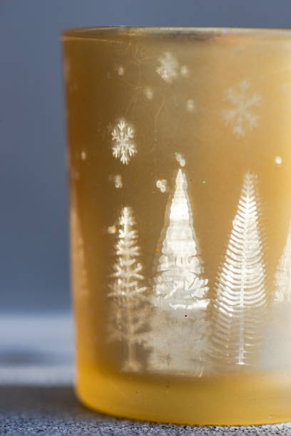 Christmas candle glass in sunny day with fairy shadows
