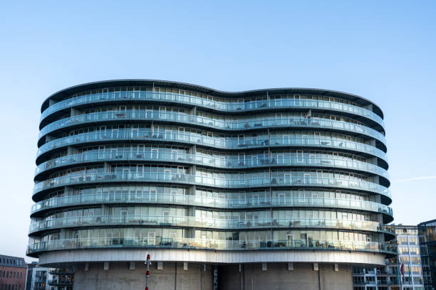Modern architecture and industrial cranes meet over the calm waters of royal victoria dock in london's docklands