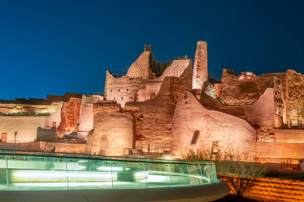 Modern glass passage to Diriyah illuminated old town walls, At-Turaif district complex at night, Riyadh, Saudi Arabia