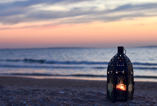 Beautiful sunset on the sea, lantern on the shore, place for text, vacation, summer, blue, orange