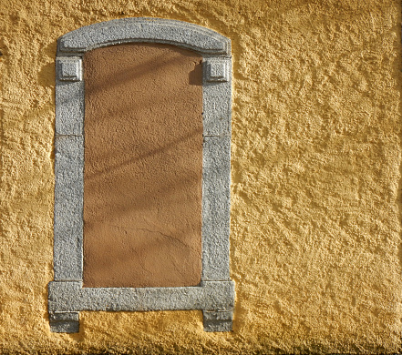 Yellow wall with a boarded up brown window