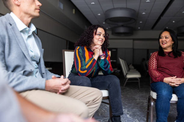 mujer latina sonriendo durante una discusión grupal - 7655 fotografías e imágenes de stock