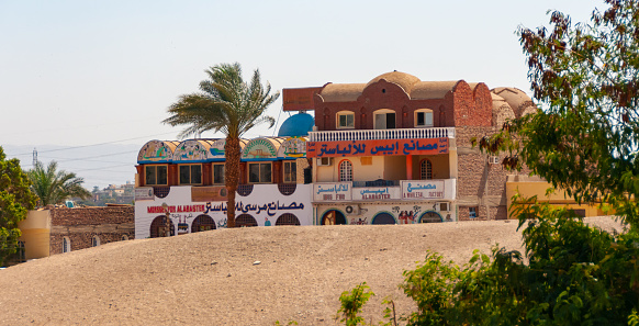 Luxor, Egypt - March 01, 2019: advertising signs on an Egyptian house with shops and workshops, Egypt