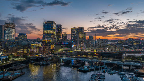 boston harbor with barges and yachts with modern city skyline at sunset, and famous leonard p. zakim bunker hill memorial bridge. - leonard p zakim bunker hill memorial bridge ストックフォトと画像