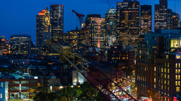 construction cranes in front of the illuminated night city skyline of boston, massachusetts. - boston aerial view charles river residential structure 뉴스 사진 이미지