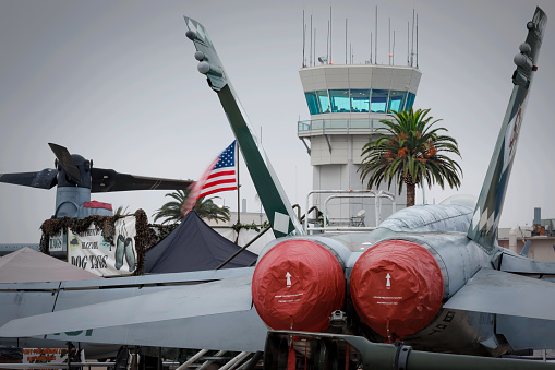 Miramar, California, USA - September 24, 2023: The control tower at Marine Corps Air Station Miramar and an F-18 Hornet on display at America's Airshow 2023.