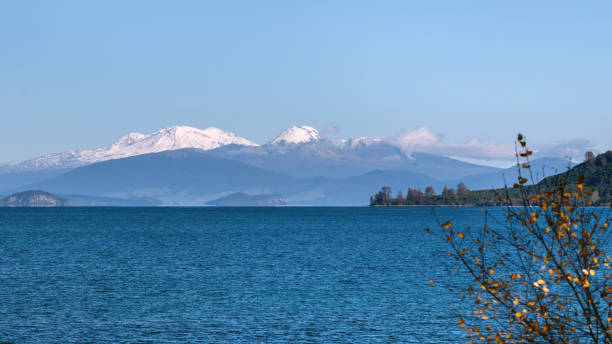 Lake Taupo and blue snow capped mountains in Tongariro national Park, New Zealand