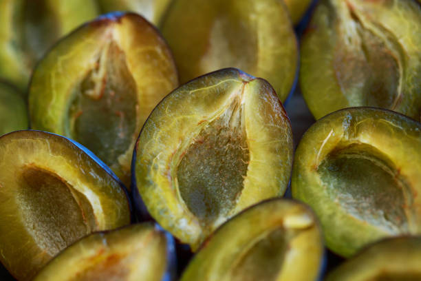 background of organic ripe plum halves top view